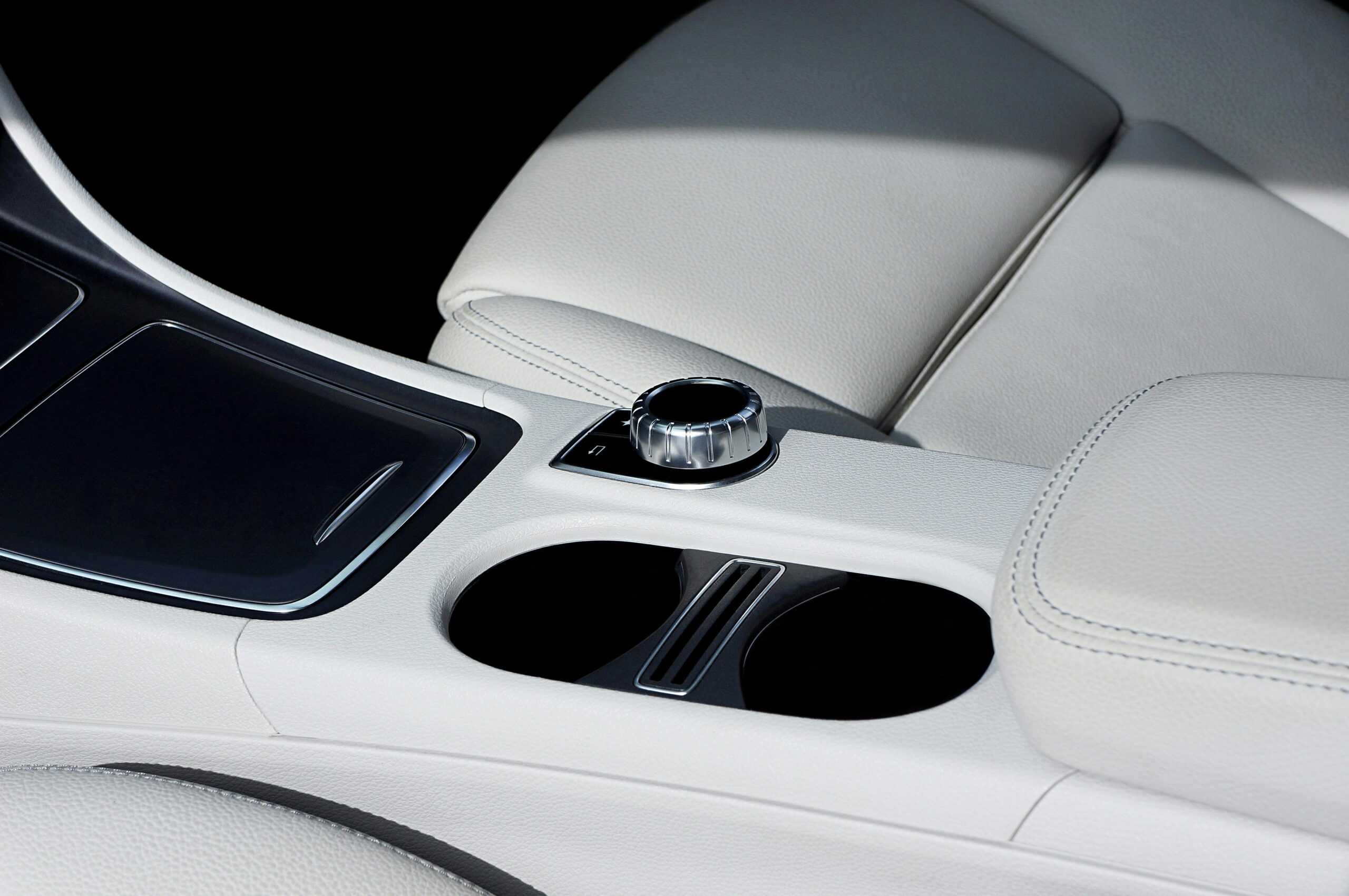 Close-up view of a luxury car interior showcasing elegant leather seats and control panel.